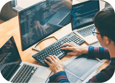 persona trabajando en varios ordenadores